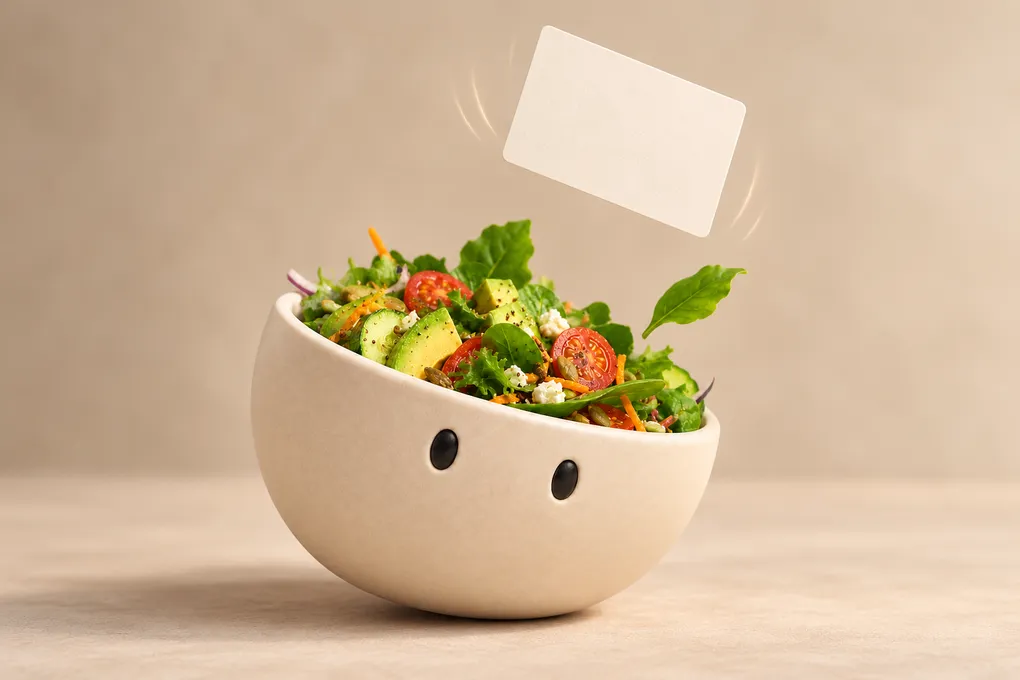 Das Plateful-Maskottchen, eine Salatschale, lehnt sich zur Seite und fängt eine fallende Rezeptkarte auf